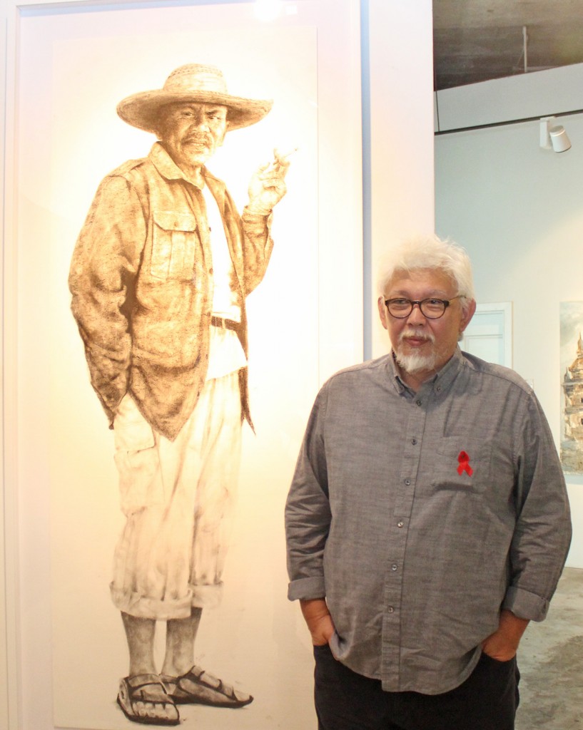 Ahmad Zakii Anwar, artist and Trustee of the Malaysian AIDS Foundation poses with one of his contributions to the ARTAID15 fundraiser ("Orang Kelantan")