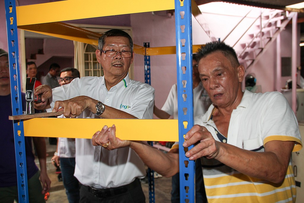 An NGC Energy Sdn. Bhd. staff (left) helps a Kuala Lumpur AIDS Support Services Society caregiver (right) assemble a shelf at Faith Helping Centre as part of the community volunteer programme held in conjunction with the MiraGas LPG cylinder sponsorship launch. Photo © 2016 Malaysian AIDS Foundation.