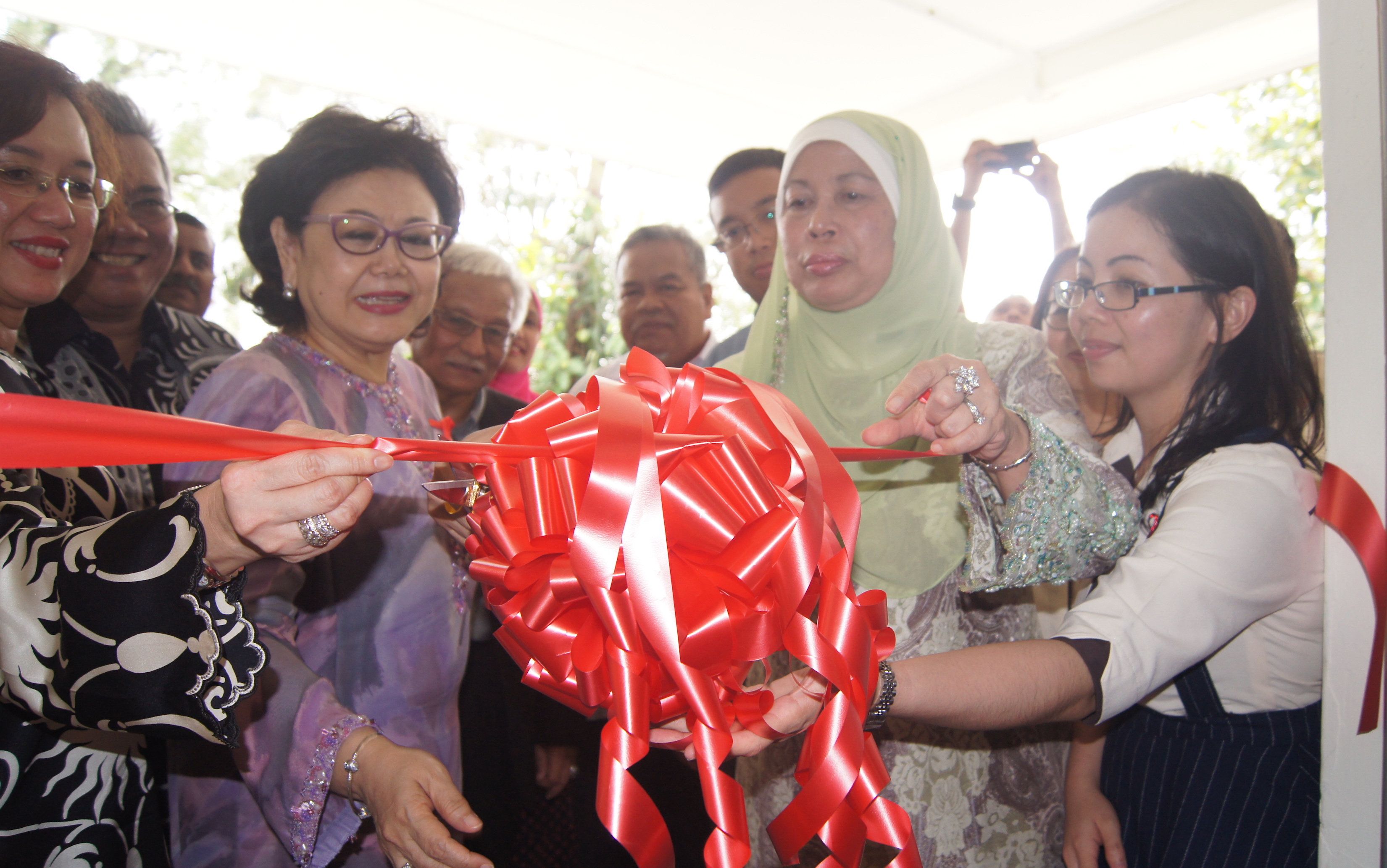 Datuk Amar Datin Patinggi Hajah Jamilah Haji Anu (second from right) cuts a ribbon to commemorate the launch of Teratak Kasih Tok Nan as Professor Dato' Dr Adeeba Kamarulzaman, Chairman, Malaysian AIDS Foundation (extreme left) and Dato' Maznah Abdul Jalil, Honorary Treasurer, Malaysian AIDS Foundation look on.